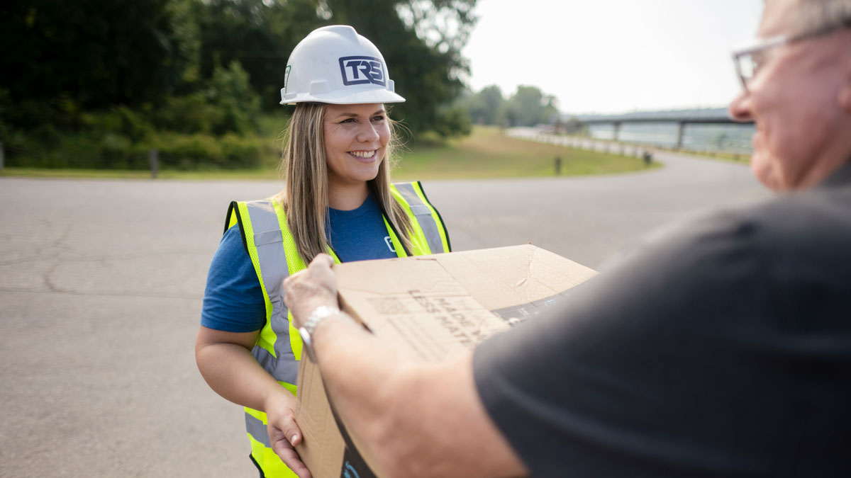 woman in work vest helping someone with carrying a package